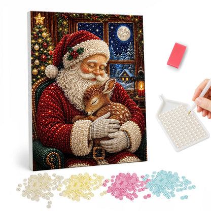 Santa Cradling a Sleeping Fawn pearl painting – Santa with closed eyes cradling a sleeping fawn in his armchair by a moonlit window
