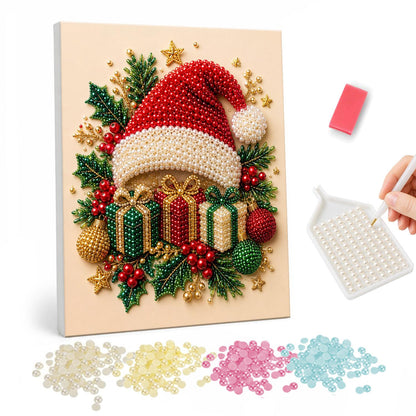 Santa Hat on a Gift Pile pearl painting – Red Santa hat resting on a pile of wrapped gifts with holly, berries and baubles on cream