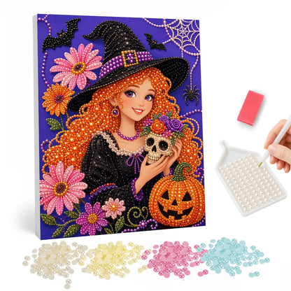 Red-Haired Witch Holding a Skull pearl painting – Smiling red-haired witch in a black hat cradling a small skull among pink flowers and a jack-o'-lantern