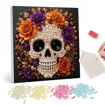 Beaded Skull with Autumn Roses pearl painting – White beaded skull framed by orange and purple roses and golden leaves on a black background