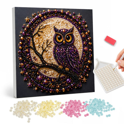 Owl on a Branch at Moonrise pearl painting – Purple owl perched on a bare branch before a golden full moon inside a round jeweled border on black
