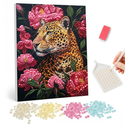 Leopard in Pink Peony Bloom pearl painting – Leopard face among large pink peonies and green leaves on a dark background