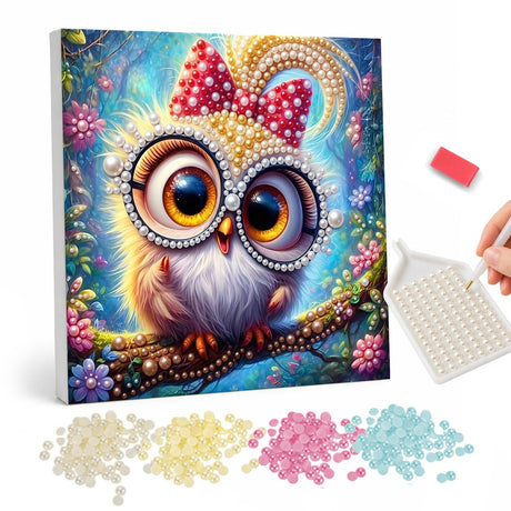 Polka-Dot Bow Baby Owl pearl painting – Fluffy owlet with huge amber eyes and a red polka-dot bow, perched on a branch among flowers