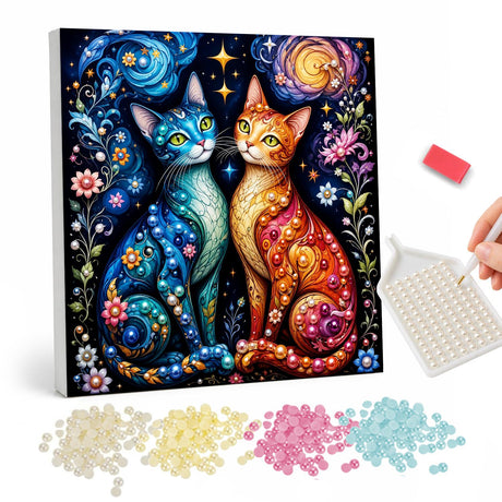 Sapphire and Amber Cat Pair pearl painting – Blue cat and orange cat sitting side by side among flowers under a swirling starry sky