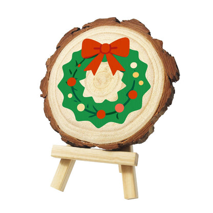 Scalloped Wreath with Red Bow paint by numbers wood slice – Flat green scalloped wreath with a big red bow and red, orange and yellow dots on a vine, painted on a pine slice on a small easel