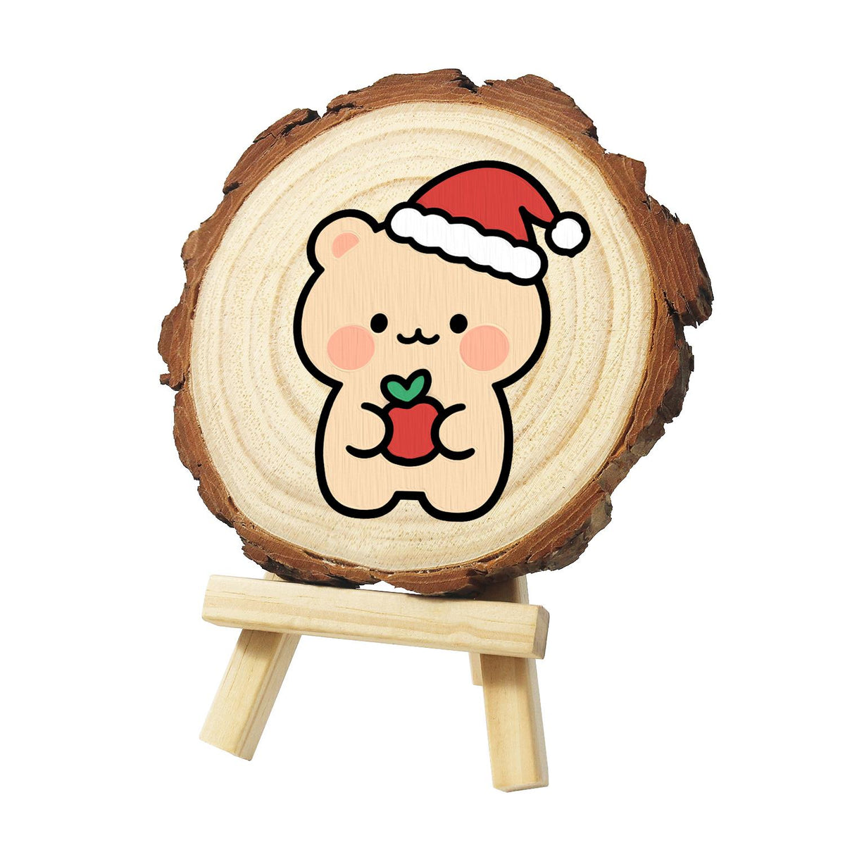 Peach Bear with a Red Apple paint by numbers wood slice – Peach-coloured bear in a Santa hat with pink cheeks holding a small red apple to its chest, painted on a pine slice on a small easel