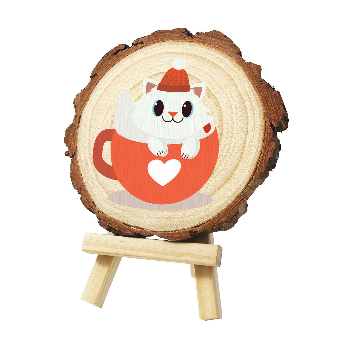 White Kitty in a Heart Mug paint by numbers wood slice – White kitten in a red knit bobble hat sitting in an orange-red mug with a white heart, painted on a pine slice on a small easel