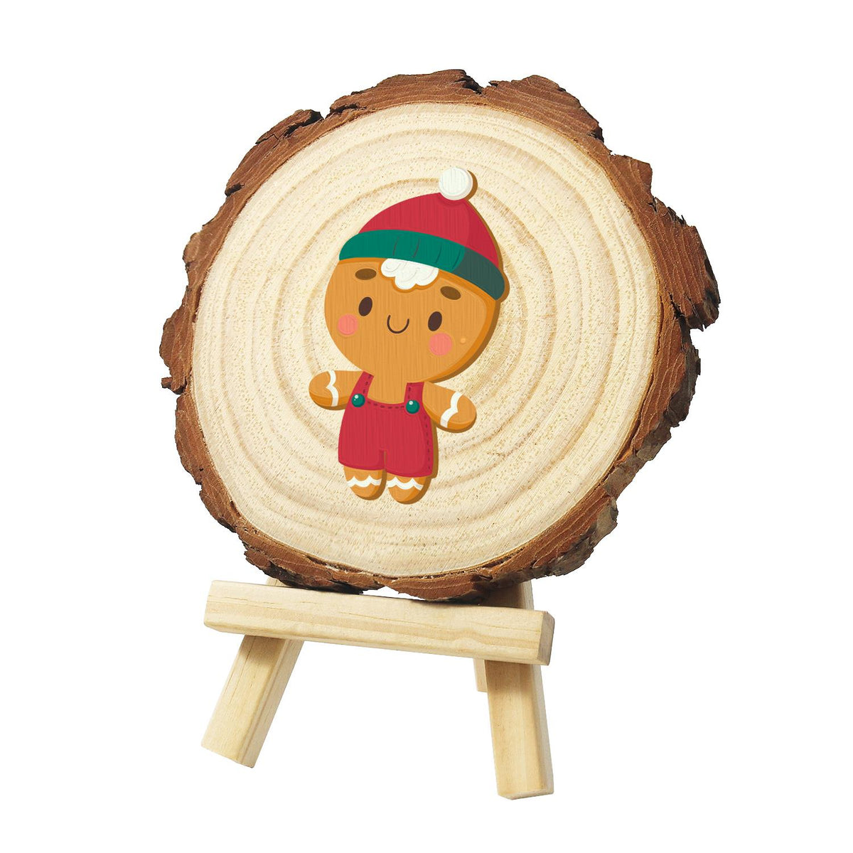 Gingerbread Boy in Red Overalls paint by numbers wood slice – Gingerbread cookie in a red and green bobble hat and red overalls, smiling with pink cheeks, painted on a pine slice on a small easel