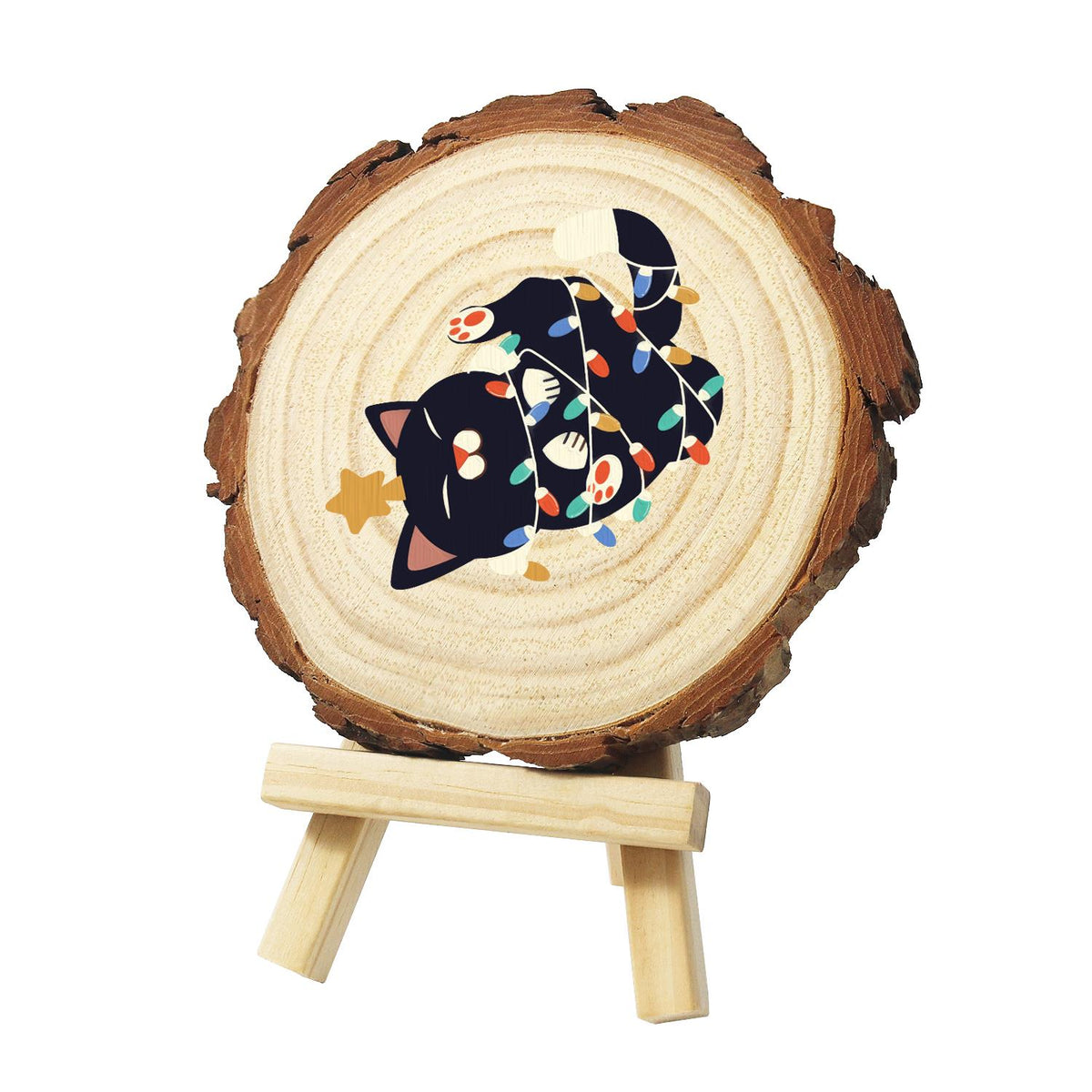 Black Cat Tangled in Lights paint by numbers wood slice – Black cat rolling on its back wrapped in colourful string lights, with a small gold star, painted on a pine slice on a small easel