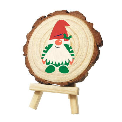 Holly-Hat Gnome in Green Stripes paint by numbers wood slice – Gnome in a red hat with a holly sprig, green and white striped outfit and green shoes, painted on a pine slice on a small easel