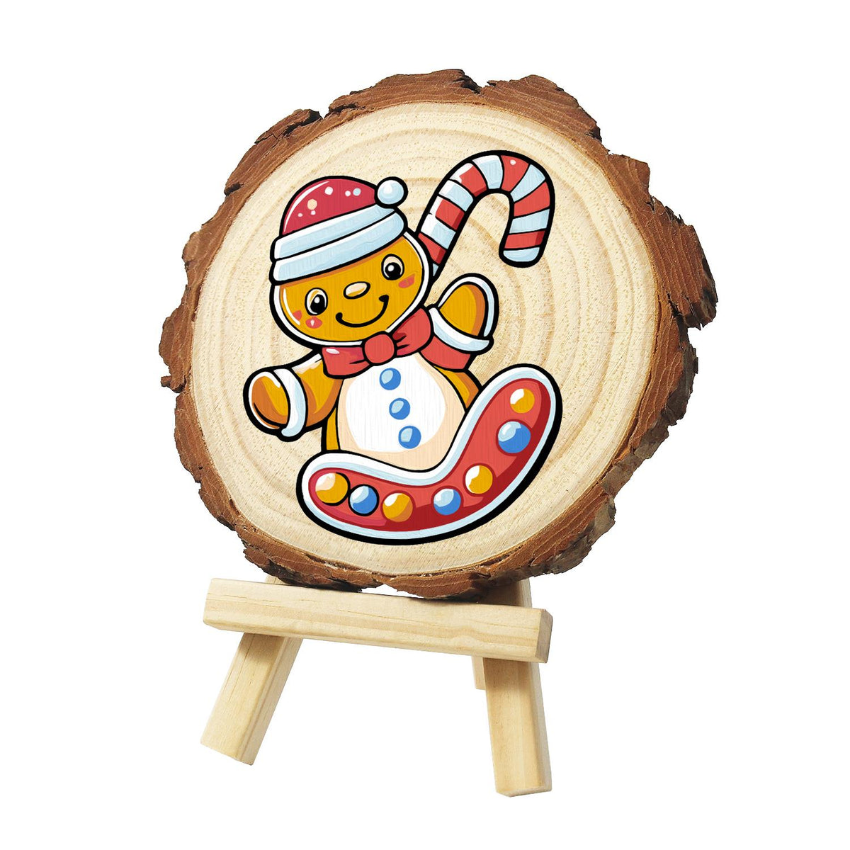 Gingerbread Kid on a Candy Sled paint by numbers wood slice – Gingerbread boy in a red winter hat and bow tie holding a candy cane, on a red sled dotted with sweets, painted on a pine slice on a small easel