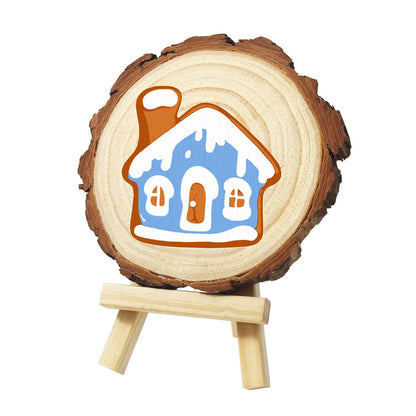 Snowy Blue Gingerbread House paint by numbers wood slice – Blue gingerbread house with a snowy white roof, chimney, arched white door and two windows, painted on a pine slice on a small easel