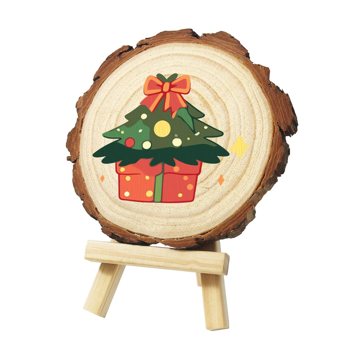 Bow-Topped Tree on a Gift Box paint by numbers wood slice – Green Christmas tree with gold and red baubles and a red bow on top, rising from a red dotted gift box, painted on a pine slice on a small easel